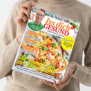 Frau in beigem Pullover hält das Magazin „Iss dich GESUND – Besser leben mit Genuss“ in beiden Händen. Auf dem Titel oben Porträt eines Mannes mit Brille, darunter große Überschrift „Die Super-Kraft der Ballaststoffe“. Weitere Texte: „Das beste Essen fürs Herz“, „Beerenszeit“, „Ernährungs-Doc für zu Hause“ und „Adipositas“. Hintergrund zeigt ein Gericht mit Teig, Tomaten, Basilikum und Schinken auf einem Holztisch.