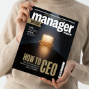 Eine hell gekleidete, langärmlige Person hält das Magazin „manager magazin SPEZIAL“ hoch; auf dem Titelblatt ist ein goldfarbener Chefsessel vor dunklem Hintergrund abgebildet. Sichtbare Texte: „HOW TO CEO – Was Sie heute können müssen, um es ganz nach oben zu schaffen“, „NETZWERKE – Welche Beziehungen sich noch lohnen“, „AKTIEN, LEBEN – Wie Chefs an sich selbst scheitern“.