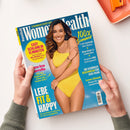 Titelbild der Zeitschrift „Women’s Health“ mit einer lächelnden Frau in gelbem Badeanzug vor blauem Hintergrund. Textinhalte u. a.: „Easy schlank in 15 Minuten“, „LEBE FIT & HAPPY – Die perfekte Ernährung für deine Longevity“, „100 % Sommer“, „Glow-Guide für schöne Haut“, „Gesundes BBQ leicht gemacht“ und „Die schönste Beachwear für jede Figur“. Hände halten das Magazin auf hellem Untergrund.