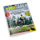 Titelbild des „e-bike TOUREN MAGAZIN“ (Ausgabe 02–26 Frühling/Sommer) mit einer weiblichen und einer männlichen Person auf E-Bikes auf einem Waldweg, umgeben von grüner Wiese und Nadelbäumen. Textelemente: „20 Traumtouren für Genießer“, „Märchenhafte Mittelgebirge“, „45 Ideen für das Reisejahr“, „E-Bike-Motoren – Volle Power“ sowie Hinweise auf Donau- und Mainradweg, Schweiz-Touren und Produkttests.