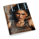 Titelblatt der Zeitschrift „ELLE“, Ausgabe Juli 2026, mit einer weiblichen Person mit dunklem, nach hinten gebundenem Haar und bronzefarbenem Oberteil vor sandfarbenem Hintergrund. Sichtbare Texte: „MAGIC GLOW – Mini-Touch-up mit Mega Effekt“, „GREECE, MY LOVE! – Das Lebensgefühl, der Look, die Locations“, „HOLLYWOOD GLAM“ sowie Namen wie Zendaya, Anne Hathaway, Charlize Theron, Lupita Nyong’o und weitere.