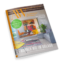Magazintitel „AW Architektur & Wohnen“ mit gelbem Logo auf grauem Hintergrund, Coverfoto zeigt ein modernes Wohnzimmer mit buntem Teppich, gelbem und orangem Stuhl, großem farbenfrohem Wandbild und hellgrauem Sofa mit Kissen. Text auf dem Titel: „52 Seiten Bad & Wellness“, „Neue Architektur aus Dänemark“, „Kunstvolle Muster & Texturen“, Hauptüberschrift „Wohnen wie im Urlaub – Häuser an Sehnsuchtsorten“.