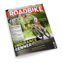 Titelblatt der Zeitschrift „ROADBIKE“ mit großem roten Schriftzug oben. Im Mittelpunkt fährt eine männliche Person in hellgrünem Radtrikot, weißem Helm und Sonnenbrille ein weißes Rennrad auf sonnigem Waldweg. Textinhalte: „ENDURANCE RENNER“, „7 Modelle im Test“, „Gravel-Racer“, „Profi­sport“, „Fitness“, „Räder von Canyon, Cube, Giant, Rose, Scott, Stevens und Storck“, sowie ein Hinweis auf Kettenöle im Laborvergleich.