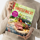 Person in beigem Strickpullover hält das Magazin „Landlust – Einfach Hausgemacht“ in den Händen; auf dem Titelbild liegt ein gegrilltes Steak auf Holzbrett mit grünem Pesto, Salat, Tomaten und Dressing-Schälchen. Sichtbare Texte: „Erdbeeren & Rhabarber“, „Einfache Rührkuchen“, „Frühkartoffeln“, „Bunte Pestos“ und „Köstliches vom Grill – mit Kalb, Forelle, Gemüse und süßen Spießen“.