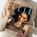 Titelseite der Zeitschrift „ELLE“, Ausgabe Juli 2026, gehalten von einer Person in beigem Strickpullover. Auf dem Cover eine weibliche Person mit dunklem Haar und braunem, strukturiertem Oberteil vor sandfarbenem Hintergrund. Sichtbare Schriftzüge: „HOLLYWOOD GLAM“, „MAGIC GLOW“, „GREECE, MY LOVE!“, „ZENDAYA“, „ANNE HATHAWAY“, „CHARLIZE THERON“, „LUPITA NYONG’O“.