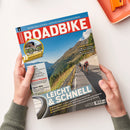Titelbild des Magazins „Roadbike“ mit roter Kopfzeile und weißer Schrift, im Hauptmotiv drei Rennradfahrer auf einer Gebirgsstraße bei sonnigem Wetter, flankiert von einer Felswand und grünen Hängen. Sichtbare Textelemente: „LEICHT & SCHNELL“, „SCHÖNES ITALIEN“, „GUT & GÜNSTIG – Test: Alu-Rahmen mit Shimano-105-Ausstattung“, Hinweise zu Laufradsätzen, Elektro-Pumpen, Sport-BHs und Service-Themen für Rennradfahrer.