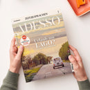 Aufgeschlagenes italienisches Sprachmagazin „ZEIT SPRACHEN – ADESSO“ mit dem Titel „Urlaub am LAGO? Ja, aber in Umbrien!“ und dem Hinweis „Mehr einfache Texte für mehr Lesespaß“. Das Cover zeigt eine Landschaft mit See, Straße und weißem Auto; zwei Hände halten das Magazin auf weißem Untergrund, daneben liegt oben rechts ein orangefarbenes Objekt.