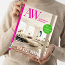 Weibliche Person im beigefarbenen Strickpullover hält ein schräg ausgerichtetes Magazin mit pinkem Titel „AW“ und der Aufschrift „Architektur & Wohnen“. Sichtbar sind außerdem „69 JAHRE RAUM FÜR INSPIRATION“, „36 Seiten Special Ferienimmobilien Einrichten & Vermieten“, ein helles Wohnzimmer sowie die Texte „Trondheim Norwegens kreative Stadt am Fjord“ und „DER NEUE NORDEN“.