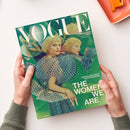 Titelblatt der Zeitschrift „VOGUE Deutschland – Collector’s Issue“ mit dem Text „EIN KALEIDOSKOP DES FRAUSEINS“, „THE WOMEN WE ARE“ und „MALA EMDE“. Im Zentrum eine hellhaarige weibliche Person in gemustertem grün-blauem Kleid, mehrfach gespiegelt vor abstrakt grünem Hintergrund. Gehalten von zwei Händen über hellem Tisch, daneben orangefarbene rechteckige Schale.