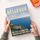 Blaues „BELLEVUE“-Magazin mit dem Aufdruck „SONDERAUSGABE“ und den Texten „HANDVERLESENE DOMIZILE – VON DER PROMI-VILLA BIS ZUR KARIBIK-INSEL“ sowie „WOHNTRÄUME ZWISCHEN FRANKFURT, FLORIDA UND FIDSCHI“. Das Cover zeigt eine Küstenvilla am blauen Meer; zwei Hände einer nicht näher erkennbaren Person halten das Magazin, daneben liegt ein orangefarbenes Schreibaccessoire.