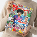 BRAVO SPORT-Magazin mit rotem, blauem und gelbem Cover, von den Händen einer Person im beigefarbenen Strickpullover gehalten. Abgebildet sind mehrere männliche Fußballspieler sowie Überschriften wie „DIE HEISSESTEN WECHSEL“, „RICHMOND IS BACK!“, „ALLES AUF ANFANG!“ und „SEHNSUCHT NACH DEM TRIPLE“; außerdem sind „2 ACTION-POSTER“ und ein „X-SPORT-KALENDER“ erwähnt.