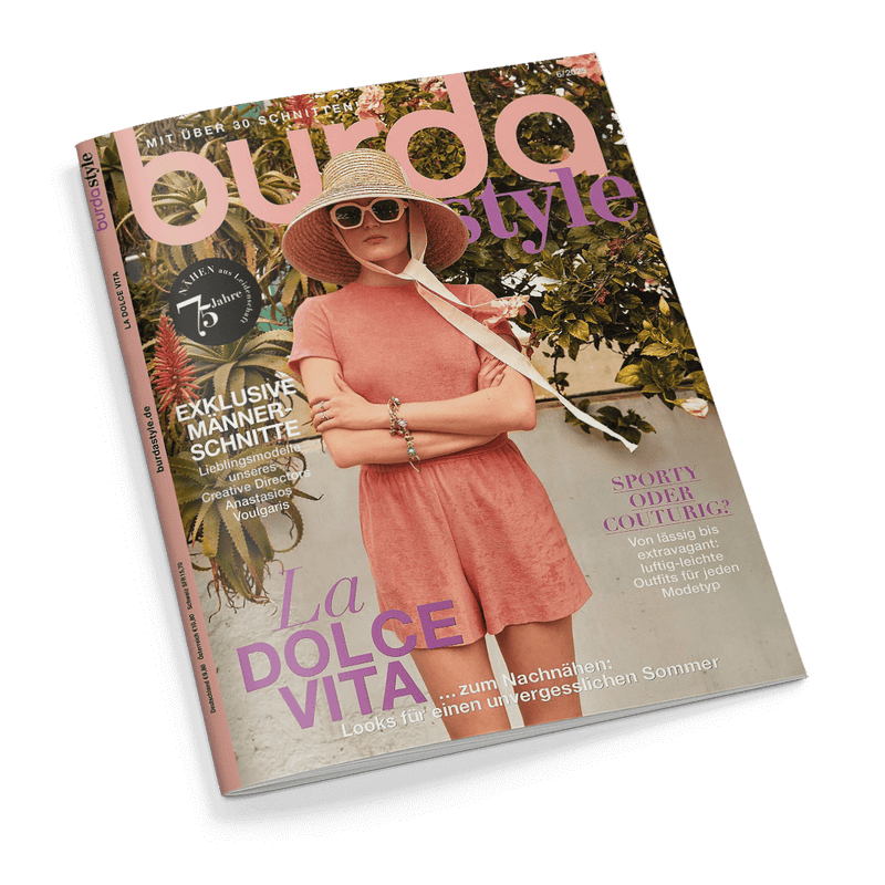 Burda Style Magazin Cover: Eine Frau mit rosafarbenem Outfit, Strohhut und Sonnenbrille vor grünen Pflanzen, Arme verschränkt. Schlagzeile: La Dolce Vita.