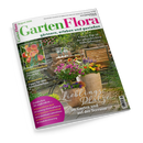 Titelbild der Zeitschrift „GartenFlora“, Ausgabe August 2026. Abgebildet ist eine Terrasse mit Holztisch, zwei Stühlen und mehreren bunten Kübelpflanzen in Töpfen aus Terrakotta. Textaufschriften: „Lieblingsplätze im Garten und auf der Terrasse“, „Unsere Top 10 der pflegeleichten Kübelpflanzen“, „Süß und aromatisch: Sonnengereifte Pfirsiche“, „Klimawandel: Tipps für den Gemüseanbau“ sowie Themenhinweise zu Sommerpflanzen und Urlaubsbewässerung.