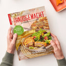Titelbild des Magazins „Landlust Einfach Hausgemacht – Mein Magazin für Haus und Küche“, gehalten von zwei Händen über einer hellen Oberfläche. Auf dem Cover ein Teller mit gefülltem Schnitzel, grünem Blattsalat und Zitronenscheibe, im Hintergrund weitere Speisen. Sichtbare Texte: „Gefüllte Schnitzel“, „Schnelle Küche“, „Frischer Spargel“, „14 Seiten Erdbeerglück“, „Einfache Bistro-Küche“.