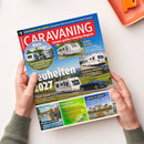 Hochformatiges Magazin „CARAVANING – Europas großes Camping-Magazin“ mit blau-rotem Cover, von zwei Händen über weißer Fläche gehalten. Abgebildet sind mehrere Wohnwagen, ein schwarzes Cabriolet und Landschaften; lesbare Texte umfassen „Schutzbriefe für Camper: Autopanne!“, „Klein und leicht“, „Adria Alpina“, „Fendt Apero“, „Ratgeber und Zubehör“ sowie „Camping im Loiretal“.