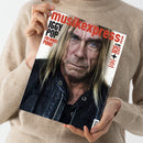 Person mit beigefarbenem Strickpullover hält ein Magazin mit dem roten Schriftzug „musikexpress“ in den Händen; auf dem Cover ist ein älterer, langhaariger Mann in schwarzer Lederjacke im Nahporträt zu sehen, daneben Texte in Schwarz und Rot: „IGGY POP – Für immer Punk!“ sowie Hinweise auf Artikel über „30 Jahre Spice Girls“ und weitere Themen.