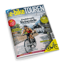 Cover des Magazins e-bike TOUREN, Ausgabe Frühling/Sommer 02-25, zeigt eine lächelnde Person auf einem E-Bike in einem Dorf mit der Schlagzeile Faszinierende Reiseziele mit dem E-Bike entdecken.