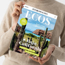 Weibliche Person in beigefarbenem Strickpullover hält ein schräg ausgerichtetes Magazin mit beiden Händen. Auf dem Cover stehen „ZEIT SPRACHEN“, „ECOS“, „SPANISCH“, „Baja California“, „Roadtrip in Mexiko von Tijuana bis Los Cabos“ sowie „WORTSCHATZ: Vacaciones en el Caribe“; abgebildet sind Kakteen, Felsen, grüne Landschaft und türkisblaues Meer.