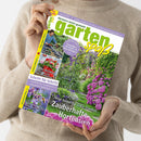 Person in beigefarbenem Strickpullover hält das Magazin „gartenspaß“ (Ausgabe Juni 2025) vor neutralem Hintergrund. Das Cover zeigt einen blühenden Garten mit violetten Hortensien und grünem Laub. Sichtbare Texte: „Gärtnern leicht gemacht“, „Neue Sorten für jeden Standort – Zauberhafte Hortensien“, „Schritt für Schritt“, „Bienenmagnete“, „Gestalten mit Rank- & Rosenbögen“ und weitere Themen zu Pflanzenpflege und Gartengestaltung.