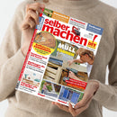 Helle Person in beigem Strickpullover hält das Magazin „selber machen! DIY – Bauen | Gestalten | Renovieren“ vor neutralem Hintergrund, Titelbild mit rotem Logo und Foto einer Person, die mit Akkuschrauber eine hölzerne Verkleidung baut; Hauptaufschrift „MÜLLTONNEN VERSTECKEN“, weitere Themen: Sonnendeck, Furnieren, Gartenbau, Praxistest und Tierfreund.