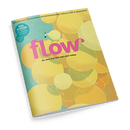Schräg fotografierte Zeitschrift mit gelbem, orangefarbenem und grünem Muster aus überlappenden organischen Formen auf türkisfarbenem Hintergrund. Auf dem Cover stehen groß „flow“ und darunter „Do what you love and start today.“; eine kleine menschliche Figur steht oberhalb des Titels, weiße Linien und Sternmotive ergänzen die Gestaltung.
