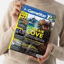 Eine Person im beigefarbenen Strickpullover hält schräg eine Zeitschrift mit blau-gelbem Cover. Sichtbar sind der Titel „Gamestar“, eine Piratenfigur vor karibischer Küste sowie die Texte „CORSAIR COVE“, „THE BLOOD OF DAWNWALKER“, „ASSASSIN’S CREED: BLACK FLAG RESYNCED“, „LOOK MUM NO COMPUTER“, „REGIONS OF RUIN“ und „AFTERLOVE EP“.