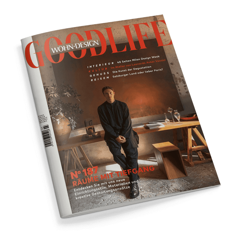 Cover des Magazins WOHN-DESIGN GOODLIFE, das einen jungen Mann in dunkler Kleidung zeigt, der an einem Holztisch lehnt, mit der Schlagzeile Räume mit Tiefgang.