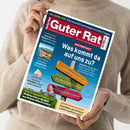 Weibliche Person im beigefarbenen Strickpullover hält eine schräg ausgerichtete Zeitschrift mit blau-rotem Cover. Sichtbare Texte: „Guter Rat“, „GELDANLAGE – Die neue Börsenblase und die Folgen“, „Was kommt da auf uns zu?“, „Reformpaket“, „Bye-bye, Bargeld?“, „Sonne & günstig“, „Sommerleckerei“, „Heckenscheren im Vergleich“ und „Wärmepumpenförderung“.