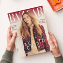 Aufgeschlagenes Magazin „Harper’s BAZAAR“, von zwei Händen über einer hellen Fläche gehalten; das Cover zeigt eine weibliche Person mit langem, welligem blondem Haar, beiger Bluse und dunkel geblümter Jacke. Lesbare Texte: „PFLICHTLEKTÜRE SMART IST DAS NEUE SEXY“, „KUNST, KULTUR, KULINARIK“, „EINE ODE AN VENEDIG“, „BACK TO CHIC“ und „DAS BESTE AUS DEN NEUEN KOLLEKTIONEN“.