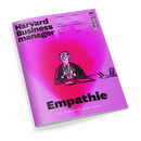 Schräg fotografiertes Magazin „Harvard Business Manager“ mit pink-violettem Cover und schwarzer Typografie. Eine gezeichnete männliche Person im Anzug formt mit den Händen ein Herz; sichtbare Texte: „Das Wissen der Besten“, „Empathie“, „Die Superkraft in der Krise“, „Preissenkungen“, „Stakeholder“, „Einstiegsjobs“ und „Überlastung“.