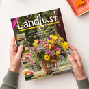 Schräg gehaltenes Magazin „Landlust“ mit dem Hinweis „NEUE STRICKIDEEN“, den Titeln „Laubsammler: Aufsatz für Schubkarren bauen“, „Basteln: Blüten aus Kürbiskernen“ und „Unverzichtbar: Ehrenamtliche Bürgermeister“ sowie „Der Herbst zieht ein“. Das Cover zeigt einen herbstlichen Blumenstrauß in einem Topf, drei kleine Bildfelder links und zwei Hände in grauen Strickärmeln; rechts oben liegt ein orangefarbenes Tablett.
