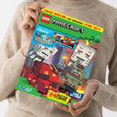 Von zwei Händen gehaltenes, schräg fotografiertes LEGO-Minecraft-Comicmagazin mit grünem Cover, gelbem Rand und pixelartiger Szene mit Minecraft-Figuren, Gebäuden und Lava. Sichtbare Texte: „COMIC SPECIAL“, „HIT ORIGINAL LEGO SET!“, „LEGO“, „MINECRAFT“, „ZWEI TOLLE COMICS!“, „EIN WILDER TRIP DURCH VERSCHIEDENE DIMENSIONEN!“, „MUTPROBE IM NETHER!“, „COOLE AKTIONEN“ und „20 SEITEN CRAFT INHALT“.