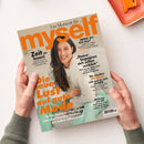 Schräg von oben fotografierte Zeitschrift „myself“ mit beigefarbenem Cover, großen orangefarbenen Buchstaben und dem Porträt einer lächelnden Frau mit langen dunklen Haaren und weißer Kleidung. Sichtbare Texte: „Ein Moment für …“, „Zeit zu lesen!“, „WOW, bin ICH das?“, „Die neue Lust auf gute Mode“ und „Echte Fashion-Highlights von leuchtenden Farben bis tollen Silhouetten“; die Zeitschrift wird von zwei Händen gehalten.