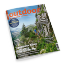 Schräg abgebildetes Outdoor-Magazin mit orangefarbenem Titel „outdoor“ und Unterzeile „WANDERN. REISEN. ABENTEUER.“; das Cover zeigt eine alpine Felslandschaft mit Wald, Bergen, einem erwachsenen Mann und einer kleineren Person auf einem Wanderweg. Sichtbare Texte: „Traumhafte Alpen“, „Japans Wanderjuwel“, „Rucksäcke“, „Quer durch Deutschland“ und „Kochen & Genießen“.