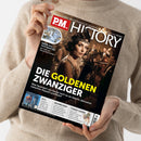 Weibliche Person im beigefarbenen Strickpullover hält ein schräg ausgerichtetes Magazin mit schwarzem, glänzendem Cover. Sichtbare Texte: „P.M. HISTORY“, „Europas größtes Monatsmagazin für Geschichte“, „DIE GOLDENEN ZWANZIGER“ und „Was fasziniert uns heute noch so an diesem Jahrzehnt zwischen Rausch und Ruin?“. Das Titelbild zeigt eine Frau mit Stirnband und Perlenkette in einer beleuchteten Gesellschaftsszene.