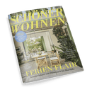 Schöner Wohnen Cover: Ein stilvolles Wohnzimmer, das sich zu einer sonnigen Terrasse mit Pflanzen und Sitzgelegenheiten öffnet, mit der Schlagzeile: Ferien Flair.
