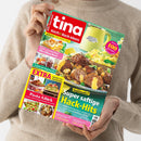 Kochmagazin „tina Koch & Back-Ideen – Genuss für jeden Tag“ mit rotem Titelkopf, türkisfarbenem Rand und gelben, pinken und grünen Textfeldern, schräg von oben fotografiert und von einer Person im beigefarbenen Strickpullover gehalten. Das Cover zeigt Hackgerichte, Kartoffelstampf, Kuchen, Pasta und weitere Speisen sowie die Texte „Mehr als 100 Rezepte“, „Herbstbegehrt! Super saftige Hack-Hits“, „Pasta-Glück“, „EXTRA“ und „Es geht ans Eingemachte“.