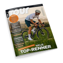 Schräg dargestelltes Cover des Rennradmagazins „TOUR“ mit der Aufschrift „EUROPAS RENNRAD-MAGAZIN NR. 1“ und „NEUE TOP-RENNER“. Ein männlicher Rennradfahrer mit grauem Helm, Sonnenbrille, weißem Trikot und dunkler Radhose fährt auf einem schwarzen Rennrad durch eine grüne Landschaft; weitere Texte nennen „Räder im Test“, „Tour de France Femmes“, „Deutschland-Tour“ und „Regeneration“.
