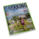 Schräg abgebildetes Magazincover „TREKKING – WANDERN & OUTDOOR“ mit grünem Rand und dem Schriftzug „WIR-LEBEN-OUTDOOR.DE“. Das Titelbild zeigt drei wandernde Personen, zwei weibliche und eine männliche, vor einer alpinen Landschaft mit Berghütte, Wiesen und Bergen; sichtbare Texte sind „14 Traumwege, die Fernweh wecken – Von Italien bis Irland“, „Trentino“, „Tour der Kontraste“, „Irlands Südwesten“ und „Sommerbekleidung“.